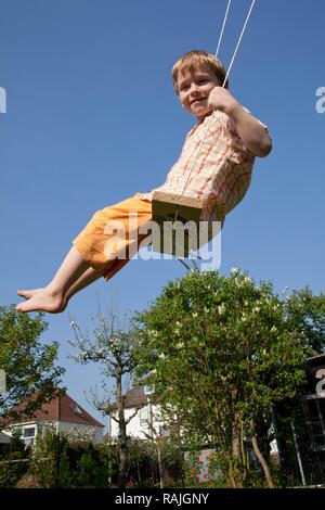 Kleiner Junge auf einer Schaukel Stockfoto