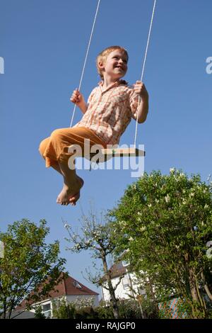 Kleiner Junge auf einer Schaukel Stockfoto