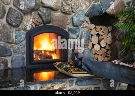 Mann mit seinen Füßen bis entspannend, vor seinem Haus Kamin, MT, USA Stockfoto