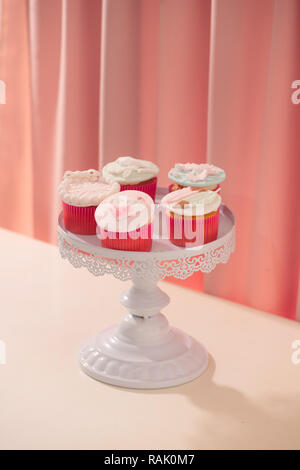 Viele leckere Cupcakes. Zum Valentinstag Liebe Cupcake auf Tabelle auf hellen Hintergrund Stockfoto