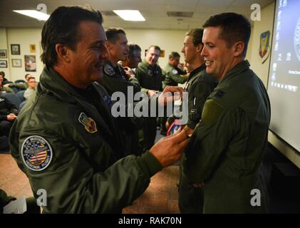 Us-Luftwaffe Kapitän John Waters, F-16 Viper Demonstration Team Pilot, erhält sein Erbe Flug Patch nach dem h Heritage Flight Training Kurs an der Davis-Monthan Air Force Base, Ariz., Feb 12, 2017. Die HFTC erlernt und trainiert militärische und zivile Piloten auf, wie man in einer engen Formation mit dem Zweiten Weltkrieg, Vietnam fliegen, und der aktuelle Tag Kampfflugzeuge. Der Kurs endete mit Wasser seine Patch von einem Veteran Heritage Flight Pilot und kennzeichnet den Abschluss seiner Ausbildung. Stockfoto