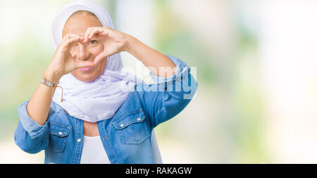 Mittleres Alter östlichen arabischen Frau mit arabischen Hijab über isolierte Hintergrund tun Herzform mit Hand und Finger lächelnd durch Zeichen Stockfoto