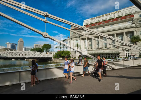 Touristen Cavenagh Brücke überspannt den Fluss Singapur, Singapur, im Hintergrund Anderson Bridge (l) und Fullerton Hotel (r) Stockfoto