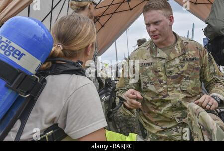 Us-Armee finden Sgt. Ryan A. Garvey, einem chemischen, biologischen, radiologischen und nuklearen Fachmann mit der 329 Unternehmen der chemischen Industrie in Orlando, Fla., bereitet seine Soldaten für eine chemische Aufgabe in einer gemeinsamen Gefahr material Übung mit der US-Armee und die miami-dade Feuerwehr Abteilung am Hafen von Miami, Feb 18, 2017. Die 329. der chemischen, biologischen, radiologischen und nuklearen (CBRN) Unternehmen (Aufklärung und Überwachung) von Orlando, Fla., 469Th der Armee finden im Krankenwagen, von Wichita, Kan. und Florida National Guard der Zivilgesellschaft Support Team, verbrachte den Tag t Stockfoto