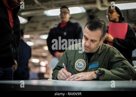 Pazifik (Feb. 20, 2017) Kapitän Craig Clapperton, kommandierender Offizier der Flugzeugträger USS Theodore Roosevelt (CVN 71), Schilder "Wir sind TR" Verträge für Segler auf dem vorwärts Chaos deck. "Wir sind TR "Verträge sind eine Vereinbarung zwischen Theodore Roosevelt Segler und der kommandierende Offizier, lohnende Vermeidung von zerstörende Entscheidungen mit speziellen Freiheit. Theodore Roosevelt ist vor der Küste von Südkalifornien die Durchführung von routinemäßigen Ausbildungsmaßnahmen. Stockfoto