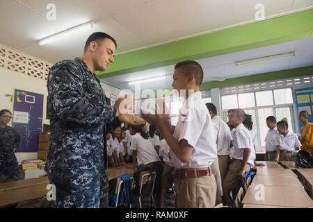 RAYONG, Thailand (Feb. 14, 2017) der US-Marine Elektronik Techniker 2. Klasse Kristopher Friseur spielt ein Spiel mit einem Studenten während eines kulturellen Austausch im Wat Samnak Thon Grundschule als Teil der Übung Cobra Gold 2017. Wie im letzten Jahr, Cobra Gold 2017 betont die Koordination bei den Civic Action, wie humanitäre Hilfe und Katastrophenhilfe, um regionale Kooperation und Zusammenarbeit in diesen wichtigen Bereichen zu erweitern. Stockfoto