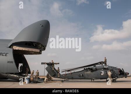 Flieger an die 823 Maintenance Squadron Last zugewiesen wird, um ein HH-60G Pave Hawk vom 66th Rescue Squadron in eine C-5 M Super Galaxy von Dover Air Force Base, Arizona, auf der Flightline im Al Asad Air Base, Irak, 13.02.2017. Der rescue Squadron war eine Umschichtung auf der Nellis Air Force Base, Nevada, nach Monaten Unterstützung von Combined Joint Task Force - inhärenten Lösen. CJTF-OIR ist die globale Koalition zu besiegen ISIS im Irak und in Syrien. Stockfoto