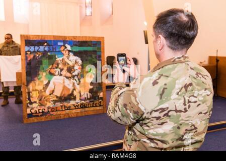 LANDSTUHL, Deutschland - Colonel William Stubbs, Commander, 30 medizinische Brigade, nimmt ein Foto eines Gemäldes von Kindern der 212th Combat Support Hospital gemacht mit dem Titel "Sorge für die Verwundeten", 15. Februar 2017. Stockfoto