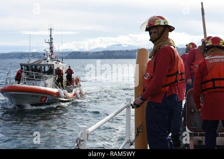 Ein Coast Guard Station Port Angeles Crew an Bord eines 45-Fuß-Antwort Boat-Medium Antriebe neben den Cutter Schwertfisch, einer 87-Fuß-Marine Protector-Class Patrouillenboot, in Port Angeles, Washington, Februar 6, 2017. Seaman Daren Elzinga Performativität von Löschanlagen nach einer Ölkatastrophe im Maschinenraum des Schiffes aufgetreten. Us-Küstenwache Stockfoto