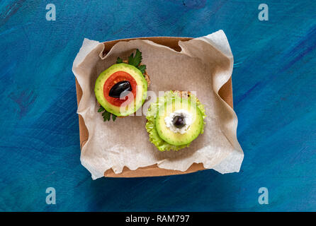 Zwei vegetarische Sandwiches in kleinen Karton auf blauem Hintergrund. Stockfoto