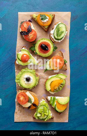 Der vegetarische Sandwiches auf Karton Papier auf blauem Hintergrund. Stockfoto