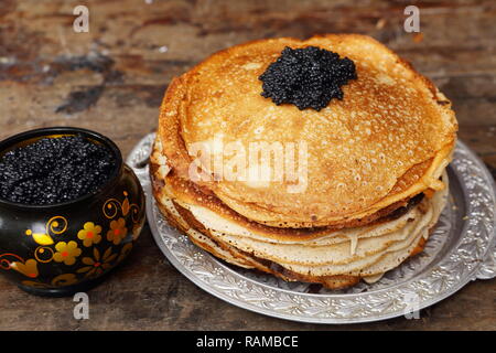 Stillleben mit Pfannkuchen und schwarzen Kaviar auf einem Holztisch Stockfoto