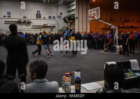 Pazifik (Feb. 19, 2017) Segler Basketball spielen in der Endrunde, die von einem 3-on-3 Turnier in den Hangar Bucht der Flugzeugträger USS Theodore Roosevelt (CVN 71). Theodore Roosevelt ist derzeit vor der Küste von Südkalifornien die Durchführung von routinemäßigen Ausbildungsmaßnahmen. Stockfoto