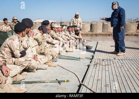 Eine irakische Sicherheitskräfte, Techniker, rechts, beauftragt Kolleginnen und irakische Soldaten bei Angriff bridging Training im Camp Taji, Irak, Jan. 21, 2017. Us-Soldaten ISF auf rasche Brücke Einlagerung mit Standard ribbon Brücken zur Unterstützung von Combined Joint Task Force - inhärenten lösen, der globalen Koalition ISIS im Irak und in Syrien zu besiegen ausgebildet. Stockfoto