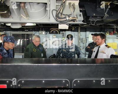 YOKOSUKA, Japan (Feb. 22, 2017) Lt.Cmdr. William Blodgett, Executive Officer der Arleigh-Burke-Klasse geführte Anti-raketen-Zerstörer USS Barry (DDG52) gibt eine Tour zu Generalleutnant Yutaka Mashiko der Japan Air Verteidigung-kraft im Pilot House und aktualisierte Schiff Bedienkonsole (SCC). Barry ist Vorwärts - in die USA 7 Flotte Bereich für Maßnahmen zur Erhöhung der Sicherheit und Stabilität in der Indo-Asia bereitgestellt - Pazifik Region. Stockfoto