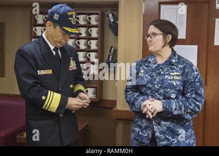 YOKOSUKA, Japan (Feb. 22, 2017) Vice Adm. Kazuki Yamashita, Oberbefehlshaber der Selbstverteidigung Flotte, Japan Maritime Verteidigung-kraft erhält eine Münze von Cmdr. Jennifer Eaton, kommandierender Offizier der Arleigh-Burke-Klasse geführte Anti-raketen-Zerstörer USS Barry (DDG52) während einer Schiffstour an Bord Barry. Barry ist, nach vorn auf die US 7 Flotte Verantwortungsbereich im Indo-Asia bereitgestellt - Pazifik Region. Stockfoto