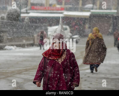 Januar 4, 2019 - Srinagar, Jammu und Kaschmir, Indien - Kaschmir Frau gesehen zu Fuß auf einer verschneiten Straße während der schneefall in Srinagar.. Schneefall in der indischen Seite von Kaschmir hat den Flugverkehr gestört, und der straßenverkehr zwischen Srinagar und Jammu, die Sommer und Winter Hauptstädte von Indiens Jammu-kaschmir Zustand, entsprechend berichten. (Bild: © idrees Abbas/SOPA Bilder über ZUMA Draht) Stockfoto