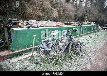 Zyklen Neben narrowboats sind in Frost auf dem Kennet und Avon, Badewanne, da Temperaturen über Teile von Großbritannien unter dem Gefrierpunkt über Nacht gefallen. Stockfoto