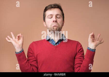 Reifen kaukasischen Mann, der versucht, sich zu entspannen Meditation. Stockfoto