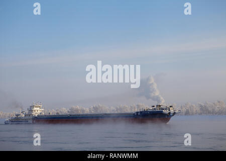 Lange Lastkahn, Fluss im kalten Winter. Stockfoto