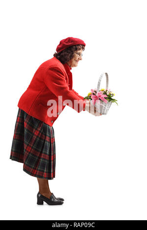 Volle Länge geschossen von einer alten Frau, die ein Korb mit Blumen auf weißem Hintergrund Stockfoto