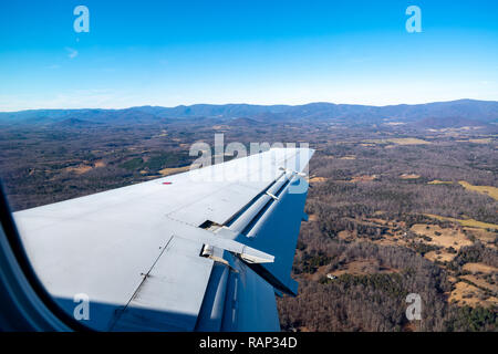 New York, USA, 29. Dez 2018 - Der Flügel eines Embraer ERJ-135 Twin Jet ist gegen die Landschaft gesehen, wie es in Richtung Charlottesville, Virginia absteigt. P Stockfoto