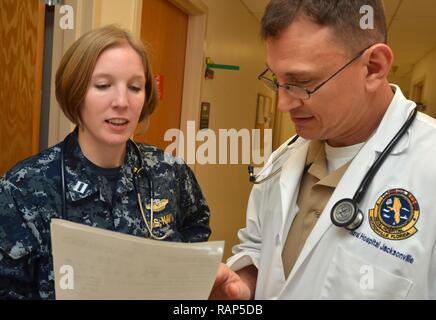 JACKSONVILLE, Fla. (Feb. 17, 2017) - Lt Amanda Antonio und Leutnant Matthew Wessner, beide von Naval Hospital (NH) Jacksonville's Medical Home Port Red Team, eine mögliche Forschungs-Projekts zu besprechen. Achtundzwanzig Familie Medizin niedergelassene Ärzte von Naval Hospital Jacksonville wurden für die Präsentation der wissenschaftlichen Arbeit an der Uniformed Services Akademie der Familie ärzte Jahrestagung im März angenommen. NH Jacksonville's Family medicine Residency Program ist die älteste und größte Marine und hat zahlreiche Auszeichnungen für Wissenschaft und Lehre erworben. Stockfoto