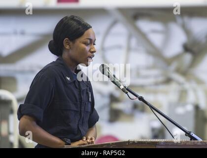 ULF von Aden (Feb. 23, 2017) Aerographer Mate's 3.Klasse Jayla Nelson singt während der afrikanischen amerikanischen und Black History Month Feier im Hangar Bay an Bord der Amphibisches Schiff USS Makin Island (LHD8). Makin Island ist in den USA der 5. Flotte Bereich für Maßnahmen zur Erhöhung der Sicherheit des Seeverkehrs auf die Verbündeten und Partnern zu beruhigen bereitgestellt, und der Freiheit der Schiffahrt und des freien Handels in der Region erhalten. Stockfoto