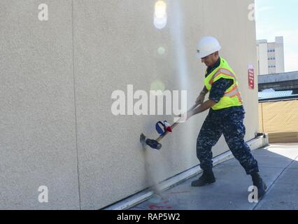 SAN DIEGO (Feb. 21, 2017) Kapitän Joel Roos, kommandierender Offizier Naval Medical Center San Diego (NMCSD) schwenkt die zeremoniellen ersten Sledgehammer markiert den ersten Schritt in Richtung zum Abriss des Gebäudes. Roos befragten die Website und besuchte mit besatzungsmitgliedern vor der Zerstörung begann. Stockfoto