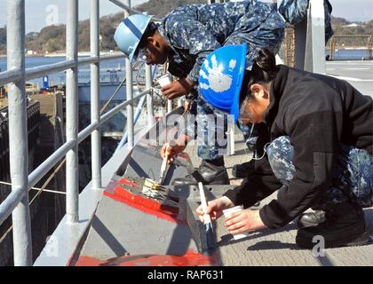 YOKOSUKA, Japan (Feb. 22, 2017) - Seemann Nathaniel Smith, Links, und Seaman Karina Ibarra Martinez, beide in die USA 7 Flotte Flaggschiff USS Blue Ridge LCC (19), Paint Bereichen Main Deck des Schiffes angebracht. Blue Ridge ist in eine umfassende Wartung, um das Schiff weiterhin als eine robuste Kommunikation Plattform in den USA 7 Flotte Einsatzgebiet zu dienen zu modernisieren. Stockfoto