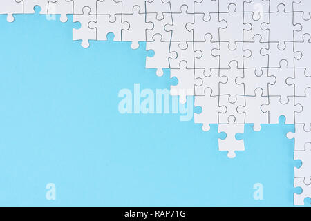 Flach mit weißen Puzzleteile auf blauem Hintergrund Stockfoto