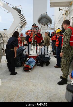 NORFOLK, Virginia (20. Februar 2017) - - USA Marine Seeleute und des Öffentlichen Dienstes Seemänner an Military Sealift Command's Hospital Ship USNS Comfort (T-AH 20) Vorbereitung für den Transport einen simulierten Unfall während einer Mann-über-Bord-Notruf bohren Sie an Bord des Schiffes, 24.02.20. Der Komfort wurde auf See zu seinen Komfort Übung (COMFEX) verhalten. Stockfoto