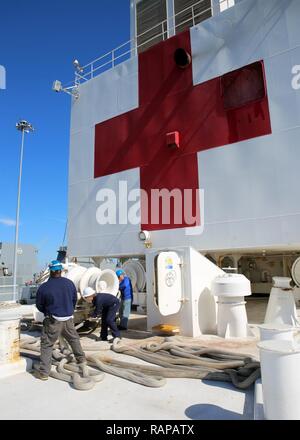 NORFOLK (Feb. 20, 2017) öffentlichen Dienst Seemänner, die militärische Sealift Command Hospital Ship USNS Comfort (T-AH 20) eine Mooring Winch verwenden, Festmacher, wie das Schiff fährt Naval Station Norfolk. Der Komfort unterwegs war Teil des 2017 Comfort Übung (COMFEX). Die Übung ist eine vierteljährliche Schulungen Batterie ausgelegt das medizinische Personal, Support und des Öffentlichen Dienstes Seeleute, die an Bord des Schiffes in ihren Pflichten kompetent bedienen zu halten. Komfort bietet ein schwimmendes, mobile, akuten chirurgischen medizinische Einrichtung, wenn man an das US-Militär genannt, und Krankenhaus Servic Stockfoto