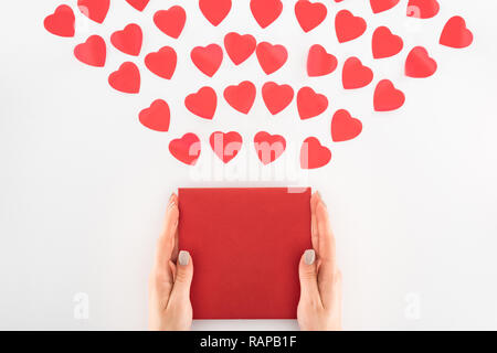 7/8 Schuß von Frau mit Umschlag unter Dutzend rote Herzen Symbole auf Weiß, st Valentinstag Konzept isoliert Stockfoto