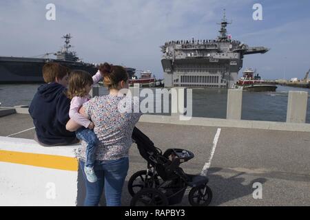 NORFOLK, Virginia (Mar 01, 2017) Familien wave, Matrosen, wie sie Mann die Schienen amphibisches Schiff an Bord der USS Bataan (LHD5). Bataan fährt Naval Station Norfolk als Teil der Bataan Amphibious Ready Gruppe (BAT ARG) Einsatz zur Unterstuetzung der Maritime Security Operations und Theater Sicherheit Zusammenarbeit in Europa und im Nahen Osten. BAT ARG umfasst Commander, Amphibischen Squadron 8, Bataan, USS Mesa Verde LPD (19), USS Carter Hall (LSD 50) und 24 Marine Expeditionary Unit (MEU). Stockfoto