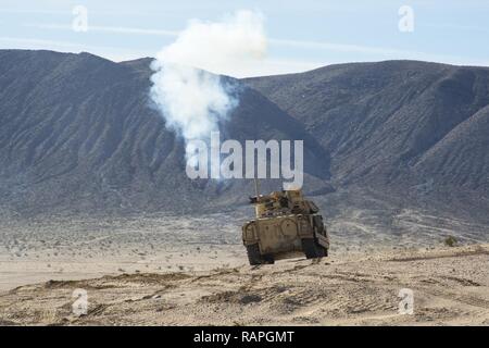 Us-Soldaten, der 2. Brigade zugeordnet, 1.Kavallerie Division, in einem Bradley Fighting Vehicle Crest einen Hügel und Feuer zu einem einzigen Schuss, während entscheidende Maßnahmen Rotation 17-04 am National Training Center in Fort Irwin, Calif., Feb 24, 2017. Stockfoto