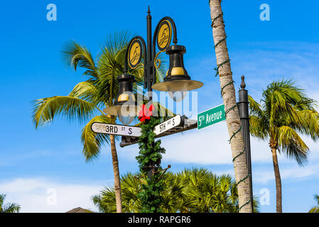 Malerische Kreuzung mit Weihnachtsschmuck zwischen der berühmten Fifth Avenue und der Third Street in der beliebten Innenstadt in Naples, Florida. Stockfoto