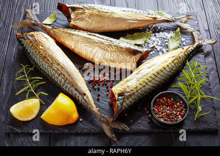 Heiß geräucherte Makrele auf schwarzem Schiefer Fach mit Salz, Pfeffer, Rosmarin und Zitrone, von oben betrachten,, cclose-up Stockfoto