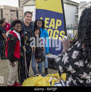 MOBILE Ala (Feb. 23, 2017) speziellen Operator 1. Klasse Brandon Peterson, ein Mitglied der US-Marine Fallschirm Team "Die Leap Frogs", posiert für ein Foto mit jungen Fans nach einem Fallschirmspringen Demonstration am Mardi Gras Park oberhalb der Innenstadt von Mobile, Ala., während Marine Woche Mobile. Die marine Woche Programm dient als Auftraggeber übertreffen Bemühung der Marine in den Bereichen des Landes ohne eine bedeutende Marine Präsenz. Stockfoto