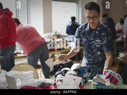 NORFOLK (Feb. 27, 2017) Hospital Corpsman 2. Klasse Diosdado Valera, zugeordnet zu dem Flugzeugträger USS George Washington (CVN 73), legt die gespendete Kleidung während eine freiwillige Veranstaltung im Ohef Sholom Tempel Suppenküche. George Washington ist in Norfolk, Virginia. homeported, Vorbereitung des Schiffes tanken komplexen Instandsetzung Wartung und Instandhaltung. Stockfoto