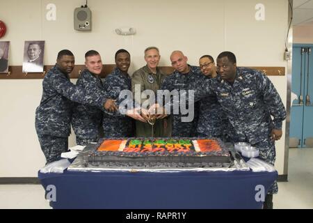 NORFOLK (Feb. 22, 2017) Kapitän Timothy Kuehhas, Mitte, kommandierender Offizier der Flugzeugträger USS George Washington (CVN 73), schließt sich an Segler schneiden einen Kuchen während des Black History Month Celebration Event auf das Chaos Decks des Schiffes schwimmenden Unterkunft Facility (FAF). George Washington ist in Norfolk homeported Vorbereitung nach Newport News, Virginia für die Betankung komplexe Überholung (RCOH) Wartung zu bewegen. Stockfoto