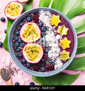 Lecker appetitlichen Smoothie acai Schale von Brombeeren und wilde Beeren, mit Passionsfrucht, Kokosflocken dekoriert, und Kakao Nibs. Serviert Stockfoto