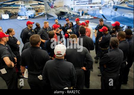 SOUTH CHINA SEA (Aug. 5, 2017) Damage Control Schulung von Teammitgliedern an Bord der Amphibisches Schiff USS America (LHA 6) Sammeln in den Hangar Bucht für eine Besprechung nach einer allgemeinen Viertel bohren. Amerika, Teil der Amerika Amphibious Ready Group, mit 15 Marine Expeditionary Unit eingeleitet, in der pazifischen Region Indo-Asia Partnerschaften zu stärken und dienen als ready-Response Force für jede Art von Kontingenz. Stockfoto