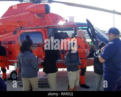 Ein fliegendes Personal von Air Station Houston bietet Studenten die Chance zu erkunden und Fragen über die MH-65 Dolphin Helikopter am 13.02.15, 2017 in Sektor Field Office Galveston in Galveston, Texas. SFO Galveston war die 2017 Coast Guard Partnerschaft in Bildung Award für die beste Zusammenarbeit im Oktober verliehen. Us-Küstenwache Stockfoto