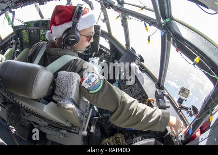 Us Air Force 1 st. Lt. Schmirgel Gumapas, ein Pilot der 36th Airlift Squadron bei Yokota Air Base, Japan zugewiesen, schaut aus dem Flight Deck Fenster einer C-130J Super Herkules Flugzeug während des Betriebs Weihnachten Fallen 2018 Weg zu der Insel Nama, Föderierte Staaten von Mikronesien (FSM), 10.12.2018. Der Flug, die Marine Adm. Phil Davidson, dem Kommandeur der US-Indo-Befehl, und lokale Führer aus der FSM, gab den Passagieren eine Erfahrung aus erster Hand, wie sich die Besatzungen der jährlichen Mission auszuführen. Stockfoto