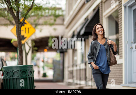 Frau zu Fuß die Straße runter. Stockfoto