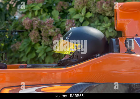 Fahrer im schwarzen Helm im Rennwagen sitzen Stockfoto