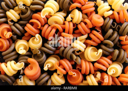 Tricolor Trottole Pasta Hintergrund Textur. Getrocknete bunte Pasta Close up Stockfoto