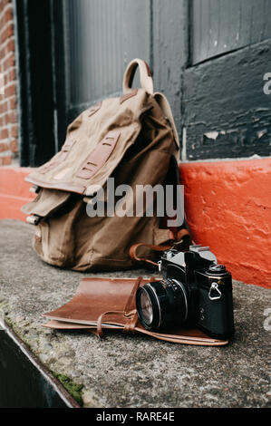 Vintage SLR Kamera mit einem Leder und Canvas Rucksack in einer städtischen Umgebung Stockfoto