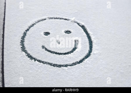 Graffiti im Schnee auf der Windschutzscheibe des Autos Stockfoto